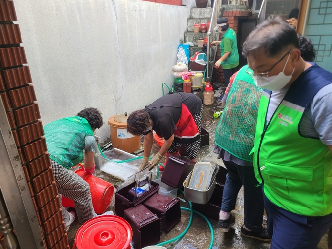 지난 25일 오후 인천 동구 송림2동 주거환경 취약가정에서 보건복지팀, 새마을부녀회, 지역사회보장협의체가 대청소를 하고 있다. ( 사진 = 동구 제공 )