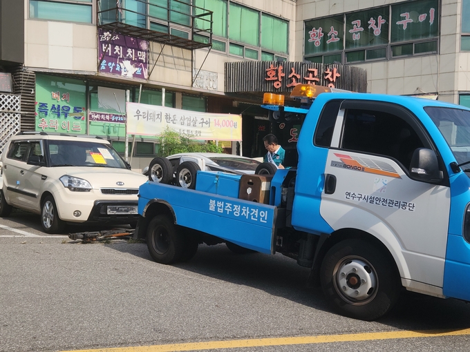 5일 오후 인천 연수구 옥련동 송도꽃게거리 공영주차장에 족쇄를 채운 무판차량을 견인차가 견인하고 있다. ( 사진 = 박지현 기자 )