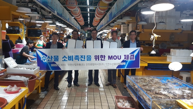 황현배 인천산업유통사업협동조합 이사장과 유기붕 인천종합어시장사업협동조합 이사장, 김정화 인천수산물유통업협동조합 이사장이 수산물 소비촉진을 위해 업무협약을 맺고 기념촬영을 하고 있다. ( 사진 = 중소기업중앙회 인천지역본부 제공 )