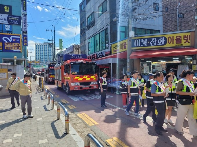오산소방서가 오색시장에서 화재예방 안전문화 캠페인 및 소방차 길 터주기 국민참여 훈련을 진행하고 있다. (사진=오산소방서 제공)