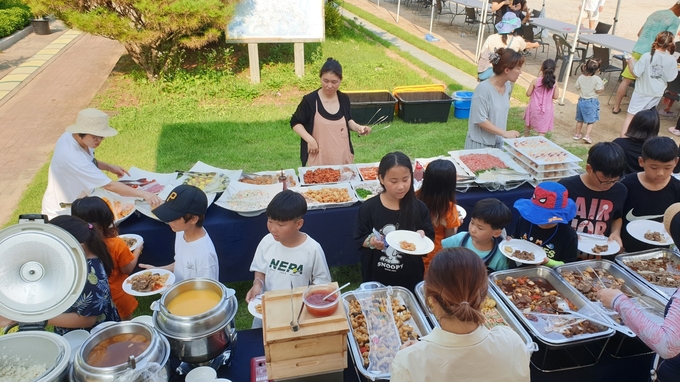 대남초등학교 학생들이 물놀이 후 학부모회가 준비한 음식을 고르고 있다. (사진=대남초등학교 제공)