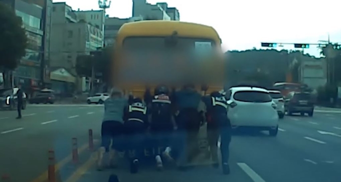  지난달 22일 멈춰 선 마을 버스를 경찰과 시민이 함께 옮기는 모습. (사지=수원남부경찰서 제공)