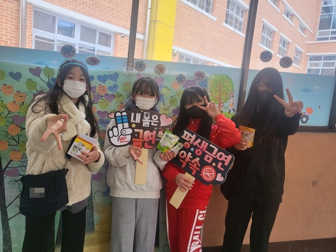 강상초 학생들이 금연 서약서 쓰기 행사에 앞서 금연 푯말을 들고 캠페인을 펼치고 있다. (사진=강상초등학교 제공)