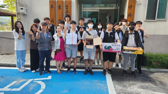 영문중학교 학생들이 학교에서 직접 키운 친환경 농작물을 이웃 노인정에 전달하고 있다. (사진=용인교육지원청 제공)