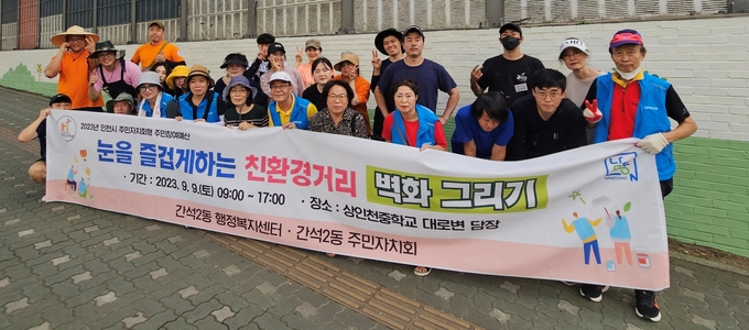 지난 9일 오후 인천 남동구 간석2동 주민자치회가 상인천중 대로변 담장에 벽화 그리기를 마친 뒤 기념촬영하고 있다. ( 사진 = 남동구 제공 )