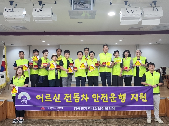 양평군 양동면 지역사회보장협의체가 어르신 안전 스티커를 들고 있다. (사진=양평군 양동면 행정복지센터 제공)