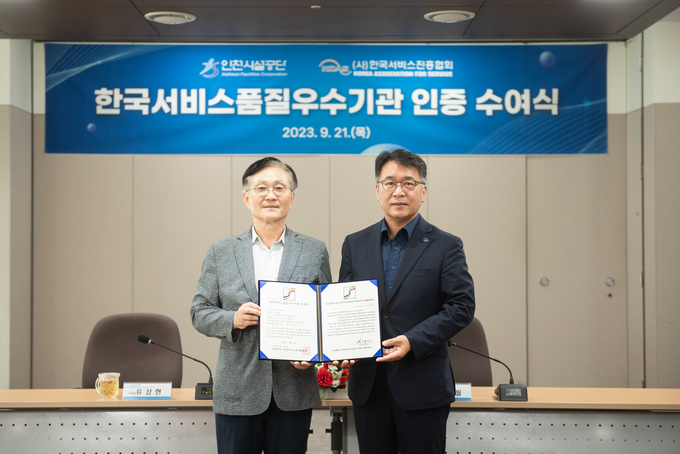 김종필(오른쪽) 인천시설공단 이사장이 한국서비스품질 우수기관으로 인증받아 수여식에서 인증서를 전달받고 기념촬영을 하고 있다. ( 사진 = 인천시설공단 제공 )