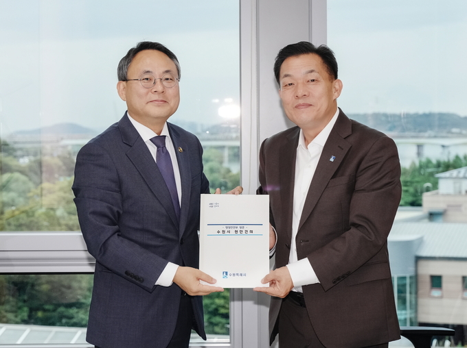지난 25일 국회소통관 내 회의실에서 열린 간담회에서 이재준 수원시장(오른쪽)이 고기동 행안부 차관에게 건의문을 전달하고 있다. (사진=수원시 제공) 
