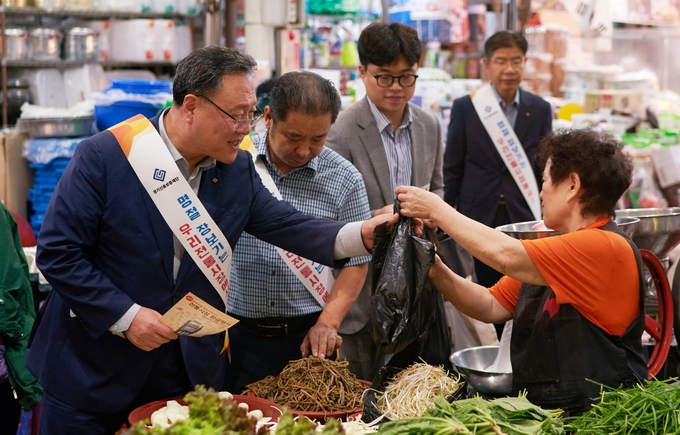 시석중 경기신용보증재단 이사장(왼쪽)이 26일 평택 통복시장을 찾아 전통시장 활성화를 위한 추석 맞이 장보기와 ‘경기 기회UP 특례보증’ 가두캠페인을 진행하고 있다. (사진=경기신용보증재단 제공)