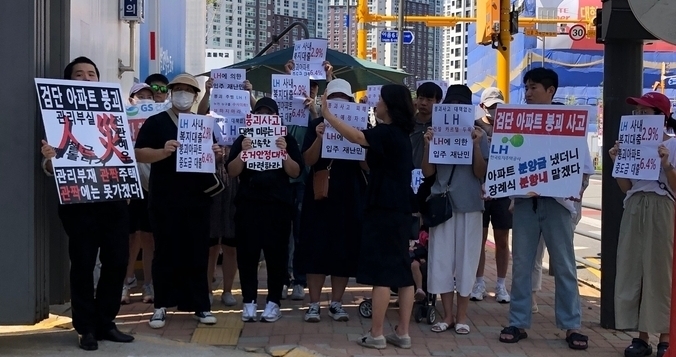 지난달 검단신도시 AA13-2블록 아파트 부실시공현장에서 입주예정자들이 피켓을 들고 서있다. ( 사진 = 박소영 기자 )