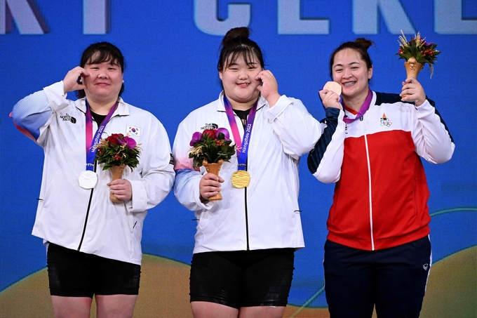 지난 7일 중국 저장성 항저우 샤오산 스포츠센터에서 열린 2022 항저우 아시안게임 역도 여자 +87㎏급에서 우승을 차지한 박혜정(가운데)이 2위 손영희(왼쪽)와 '볼 하트'를 만들고 있다. (사진=연합뉴스)