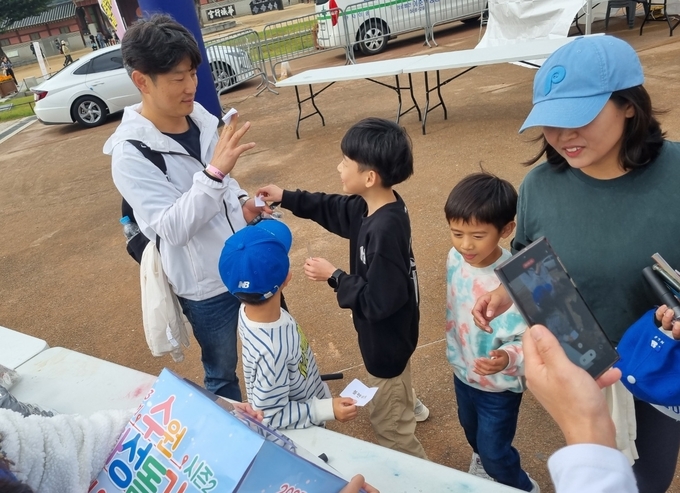 14일 오전 수원 화성행궁 광장에서 열린 ‘2023 제19회 수원화성돌기 시즌2 뱃지 워크레이스’에서 행사 참여자들이 스탬프를 모으고 있다. (사진=경기신문)