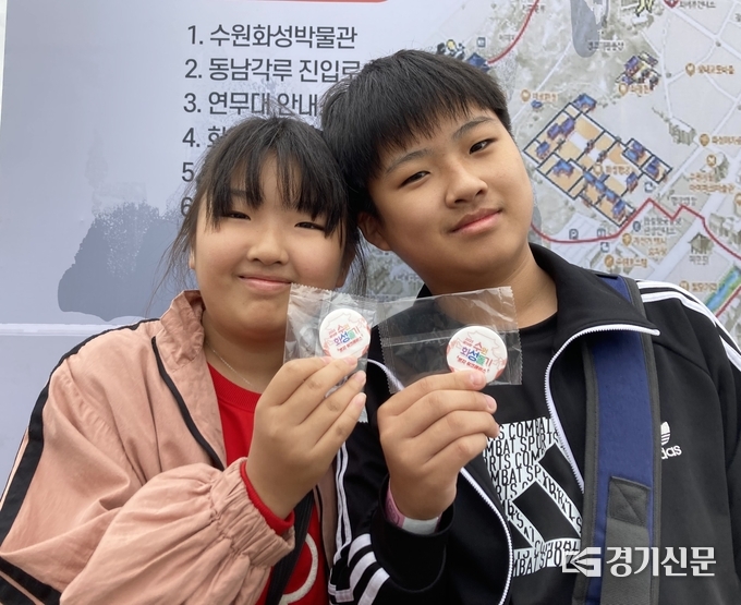 수원화성 돌기에 참여한 최지원 양(오른쪽)과 최건호 군이 배지를 들고 환하게 웃고 있다. (사진=이보현 기자)