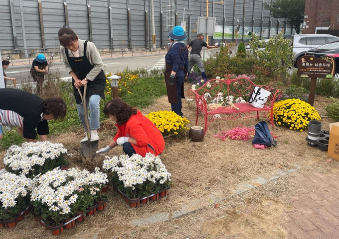 인천 남동구 남촌동 새남촌공영주차장에서 꽃피는 남촌두레 회원들과 인천생활원예네트워크 회원들이 쉼터를 조성하고 있다. ( 사진 = 남동구 제공 ) 