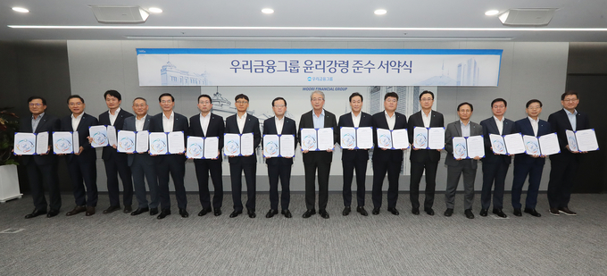 임종룡 우리금융그룹 회장(가운데)과 계열사 대표들이 서약식 후 기념촬영을 하고 있다. (사진=우리금융그룹 제공)