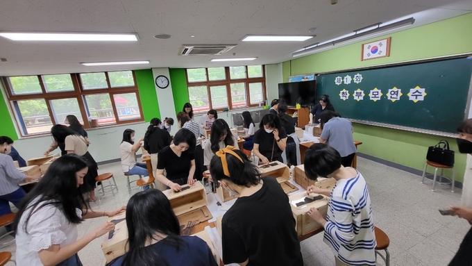  대선초등학교 학부모 동아리가 학생들을 위해 목제 보관함을 제작하는 모습. (사진=대선초등학교 제공)