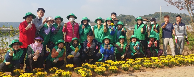지난 30일 인천 옹진군 영흥면사무소 직원들과 부녀회가 꽃길을 조성한 뒤 기념촬영하고 있다. ( 사진 = 옹진군 제공 ) 