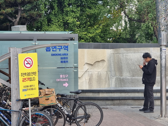 31일 오전 인천 미추홀구 주안역 인근 흡연부스 밖에서 한 시민이 담배를 피우고 있다. ( 사진 = 김민지 기자 )