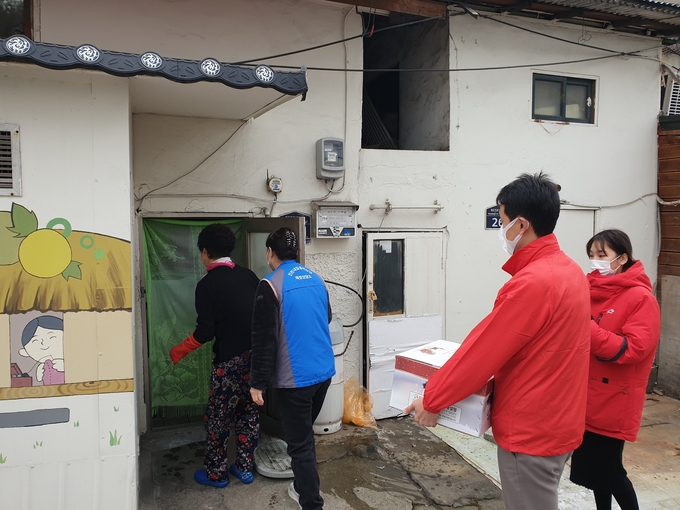 지난해 동절기에 쪽방상담소 관계자들이 쪽방 주민에게 구호구호물품 전달하고 있다. ( 사진 = 인천시 제공 )