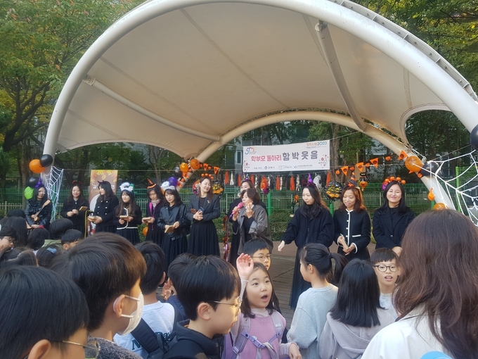 학생들이 아침 등굣길에 학부모들이 연주하는 칼림바 연주를 듣고 즐거워하고 있다. (사진=귀인초등학교 제공)