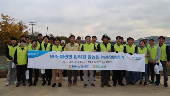 영농철 농촌일손돕기에 참여한 농협생명 임직원들이 기념촬영을 하고 있다. (사진=NH농협생명 제공)