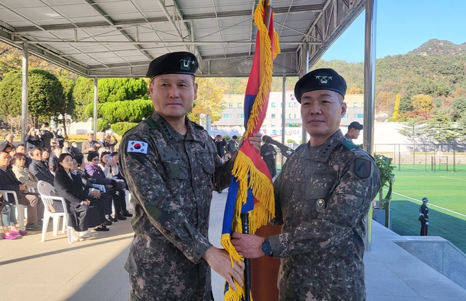 7일 수도군단사령부에서 열린 제32대 군단장 취임식에서 손식 지상작전사령관(왼쪽)이 박정택 군단장에게 부대기를 전달하고 있다. (사진=수도군단 제공)