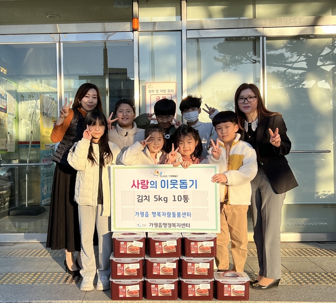 가평읍 행복자람돌봄센터가 가평읍의 어려운 이웃을 위해 가평읍 행정복지센터에 방문하여 아이들과 함께 직접 담근 김치 5kg 10통을 전달하고 있다. (사진=가평읍 행정복지센터 제공)