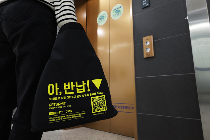 13일 경기도 수원시 경기도청에서 직원이 다회용기 포장으로 배달된 음식을 청사 안으로 옮기고 있다. (사진=연합뉴스)