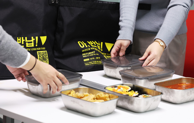 13일 경기도 수원시 경기도청에서 직원이 다회용기 포장으로 배달된 음식을 꺼내고 있다. (사진=연합뉴스)
