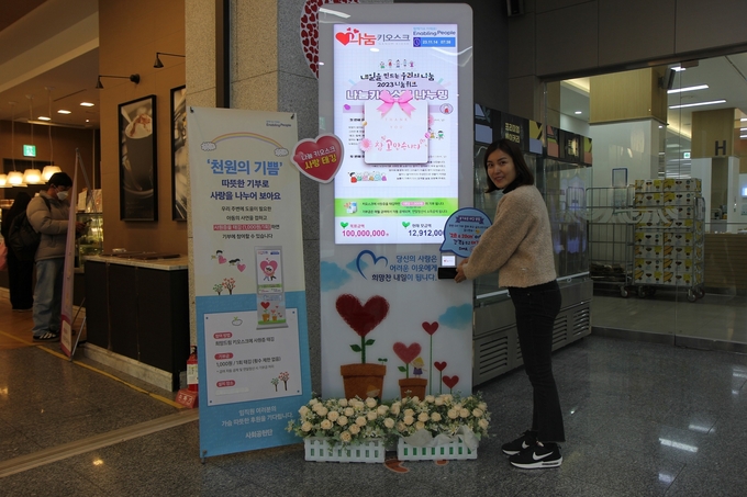 삼성전기 직원이 14일 경기 수원시 본사에서 나눔키오스크 기부에 참여한 뒤 인증 기념촬영하고 있다.