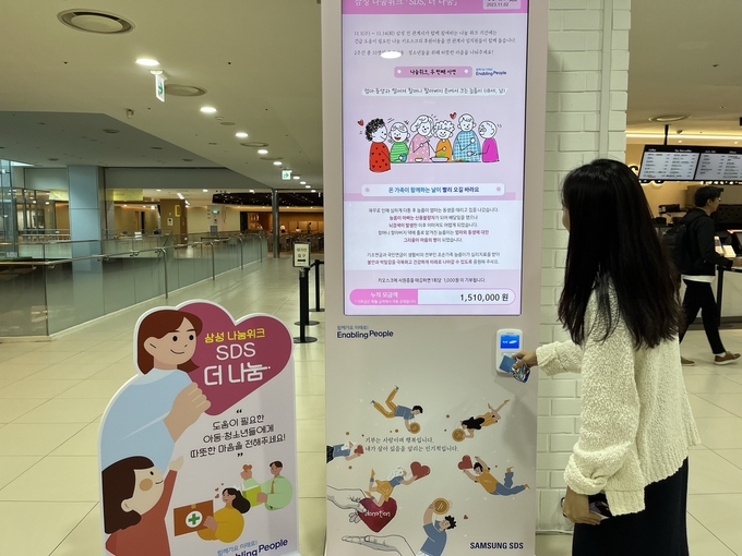삼성SDS 직원이 지난 2일 서울 잠실 본사에서 나눔키오스크에 사원증을 태깅해 기부에 동참하고 있다.