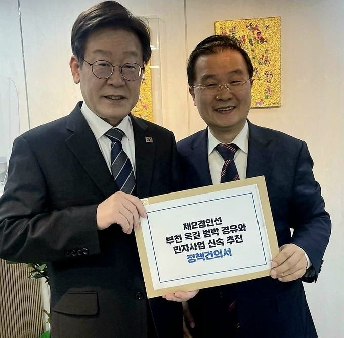이건태 변호사가 이재명 더불어민주당 대표를 만나 ‘제2경인선 부천 옥길·범박 경유와 민자사업 신속 추진 관련 정책건의서’를 전달하고 있다. (사진=이건태 변호사 제공)