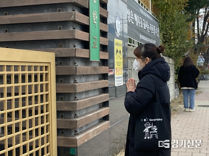 16일 오전 매원고 앞에서 수험생 자녀를 교실로 보낸 학부모가 연신 기도를 하고 있다. (사진=이보현 기자)