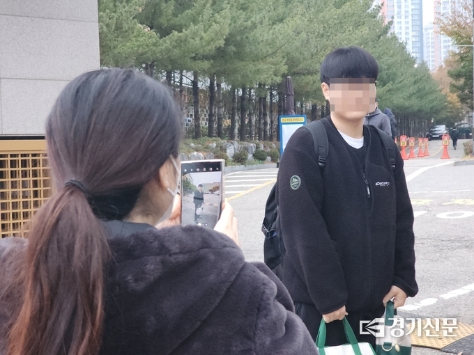 16일 오전 매원고 앞에서 한 학부모가 수험생 아들을 고사장 안으로 보내며 기념사진을 찍고 있다. (사진=박진석 기자) 
