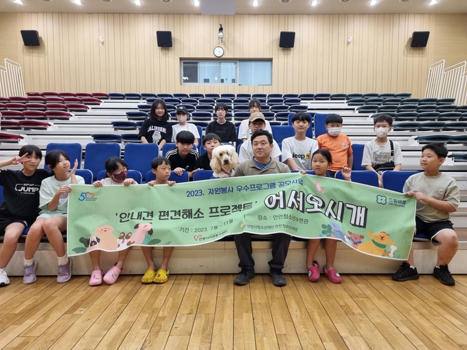 안양시청소년재단 만안청소년수련관의 '안내견 편견 해소 프로그램'에 참여한 학생 등이 프로그램을 마친 뒤 기념사진을 찍고 있다. (사진=안양시청소년재단 제공)