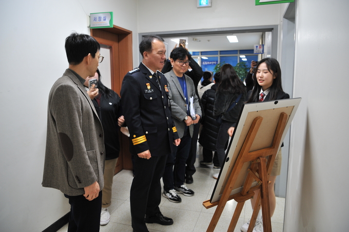  22일 정성일 수원서부경찰서장이 ‘학교폭력 예방 콘텐츠 공모전’에 참가한 학생들의 작품을 감상하고 있다. (사진=수원서부경찰서 제공)