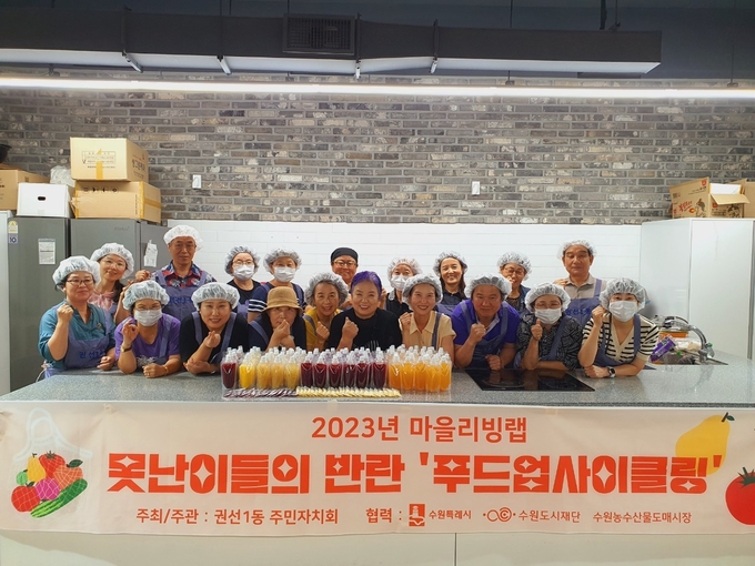권선1동 주민들이 못난이 과일을 활용해 음식을 나누는 마을리빙랩 사업 ‘푸드업사이클링’ 활동 후 기념촬영을 하고 있다.