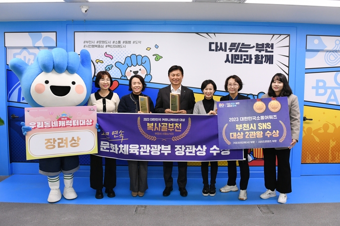 조용익 부천시장(가운데)이 사회관계망서비스(SNS), 시정소식지 복사골부천, 시 캐릭터 부천핸썹 등으로 연이은 수상 쾌거를 올린 홍보담당관 관계자들과 기념사진을 촬영하고 있다. (사진=부천시청 제공)<br>
