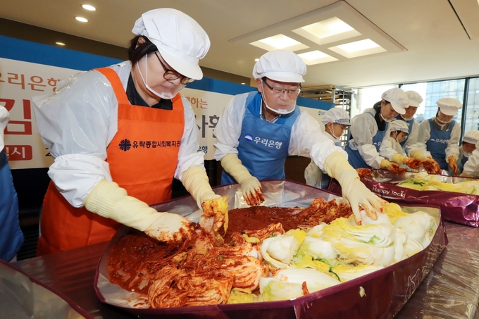조병규 우리은행장(왼쪽 두번째)이 30일 우리은행 본점 식당에서 임직원 및 가족들과 함께 직접 김장김치를 담그고 있다. (사진=우리은행 제공)