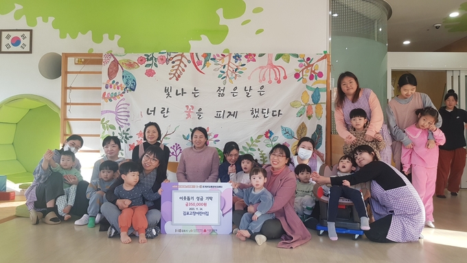 김포 고창어린이집 원아들과 학부모들이 선금을 기탁하고 기념촬영을 하고 있다. (사진=김포시 장기본동 제공)