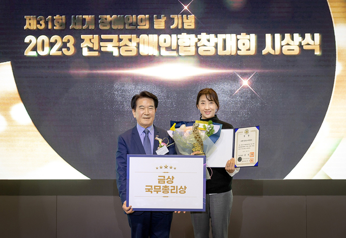 함정민 코웨이 물빛소리 합창단 지휘자(우)와 최공열 국제장애인문화교류협회중앙회 이사장(좌)이 기념 사진을 촬영하고 있다. (사진=코웨이 제공)