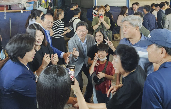 이상일 용인특례시장(가운데)이 지난 1일 용인중앙시장 별빛마당 야시장에서 시민들의 사진촬영 요구에 응하고 있다. (사진=용인시 제공)