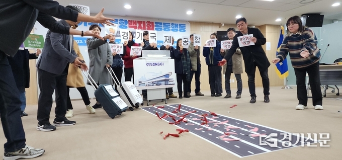  5일 ‘경기국제공항 백지화 공동행동’이 공항 활주로 모형에 붉은 고추를 던지는 퍼포먼스를 하고 있다. (사진=박진석 기자)