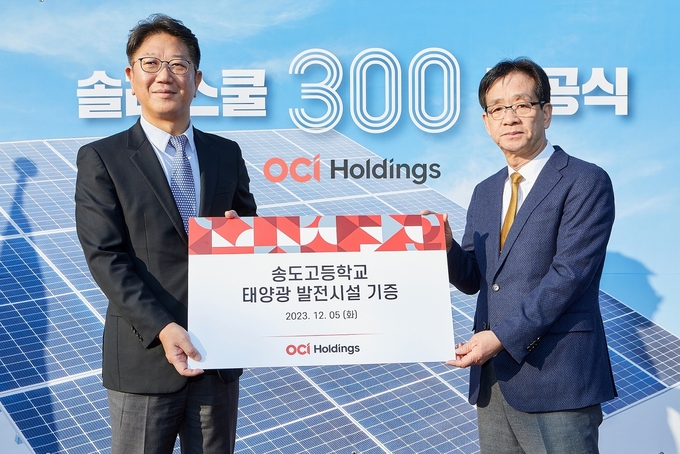 지난 5일 인천 송도고에서 열린 솔라스쿨 준공식에서 성광현 OCI홀딩스 전무(왼쪽)와 이상원 송도고 교장이 함께 기념촬영을 하고 있다. ( 사진 = OCI홀딩스 제공 )