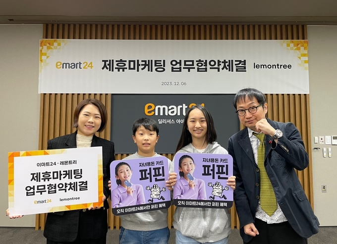 이마트24 김상현 마케팅담당(우측), 레몬트리 이민희 대표이사(좌측)가 지난 6일 오후 3시 서울 성동구 소재 이마트24에서 업무협약식 후 어린이고객들과 기념촬영을 하고 있다. (사진=이마트24 제공)