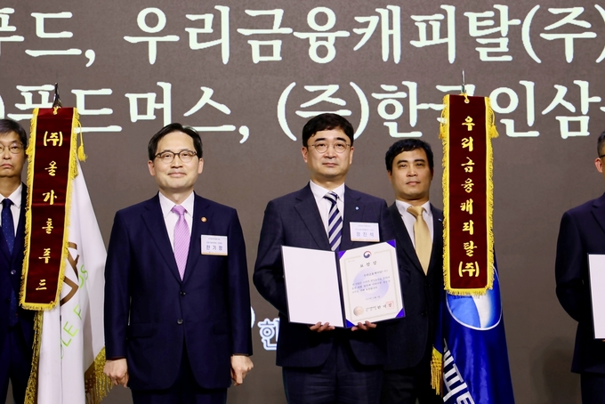 한기정 공정거래위원장(왼쪽)과 정진석 우리금융캐피탈 금융소비자보호책임자가 수여식에서 기념촬영을 하고 있다. (사진=우리금융그룹 제공)