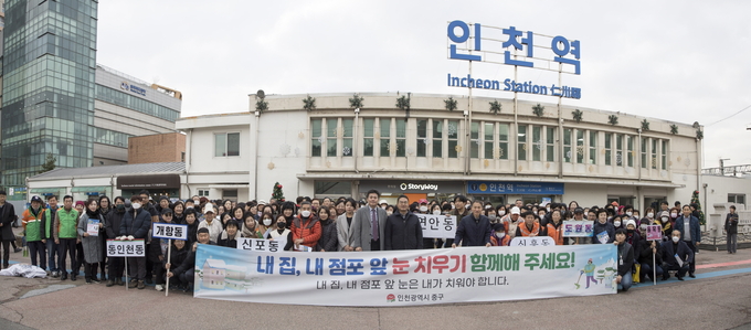 김정헌 인천 중구청장은 민관 합동으로 인천역 광장에서 '내 집 내 점포 앞 눈 치우기 캠페인'을 실시하고 기념촬영을 하고 있다. ( 사진 = 중구 제공 )