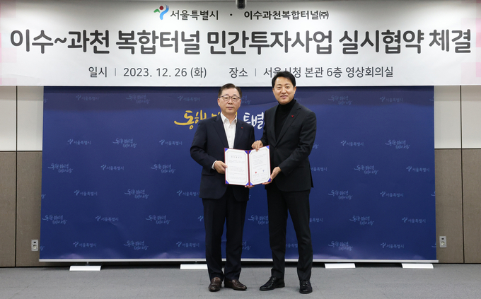 박현철 롯데건설 부회장(왼쪽)과 오세훈 서울시장(오른쪽)이 이수~과천 복합터널 민간투자사업 실시협약을 체결한 후 기념사진을 촬영하고 있는 모습. (사진=롯데건설 제공)