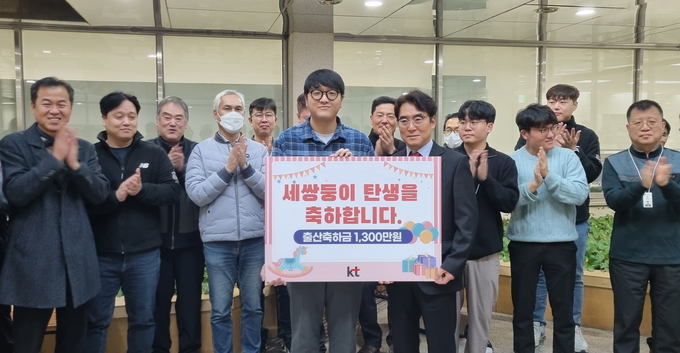 KT강남광역본부에서 세쌍둥이를 출산한 직원을 찾아 격려금을 전달하고 기념촬영을 하고 있는 모습. (사진=KT 제공)