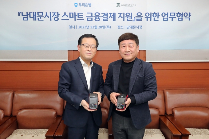 (왼쪽부터) 조병규 우리은행장과 문남엽 상인회 회장이 기념촬영을 하고 있는 모습. (사진=우리은행 제공)